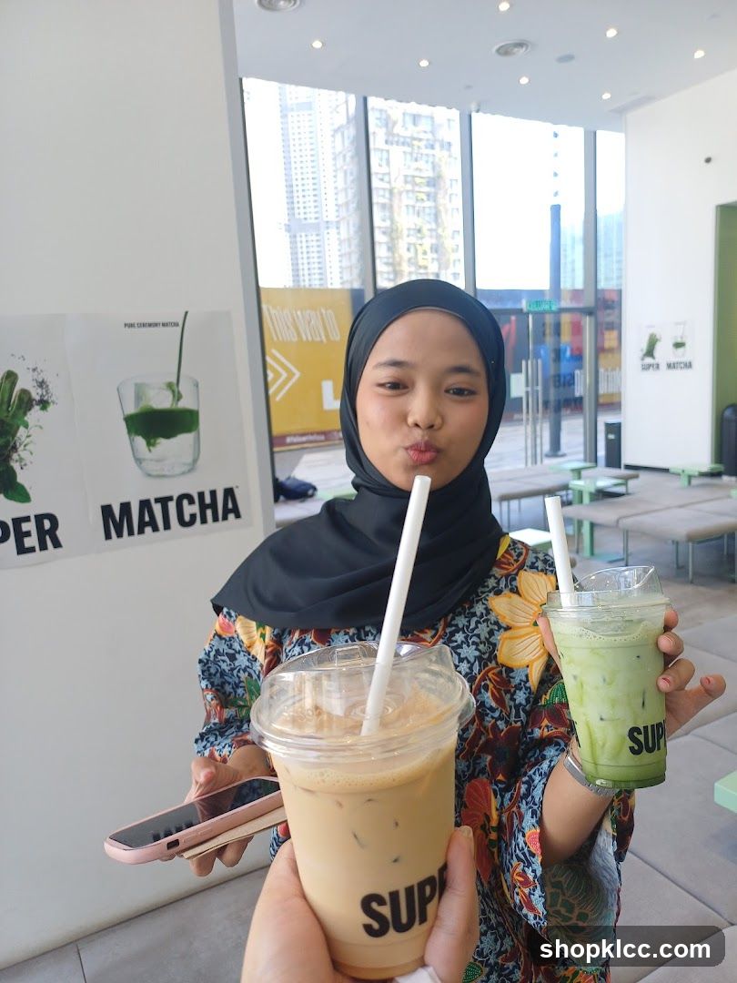 Woman holding two iced drinks