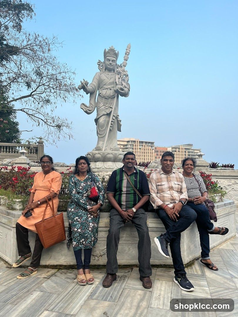 Five people posing in front of a statue