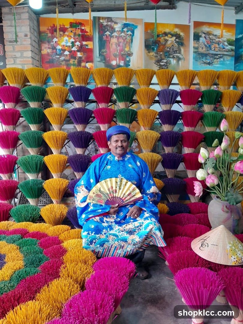 Man in traditional clothing surrounded by incense sticks