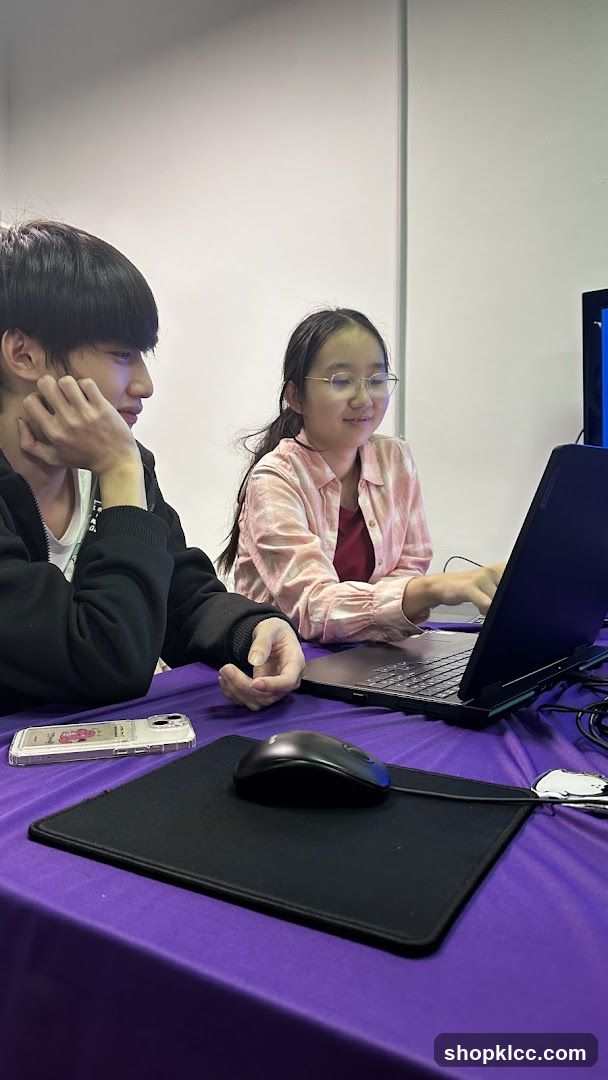 Two people working on a laptop