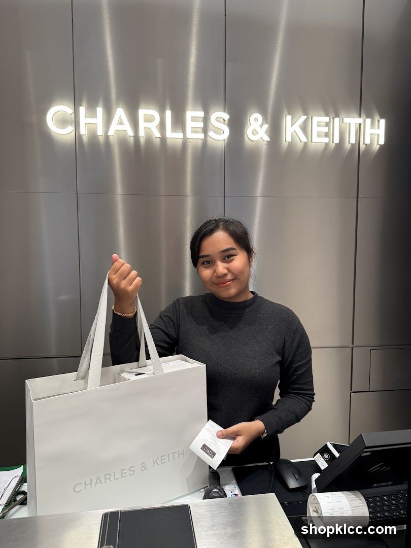Woman holding a shopping bag with Charles & Keith logo