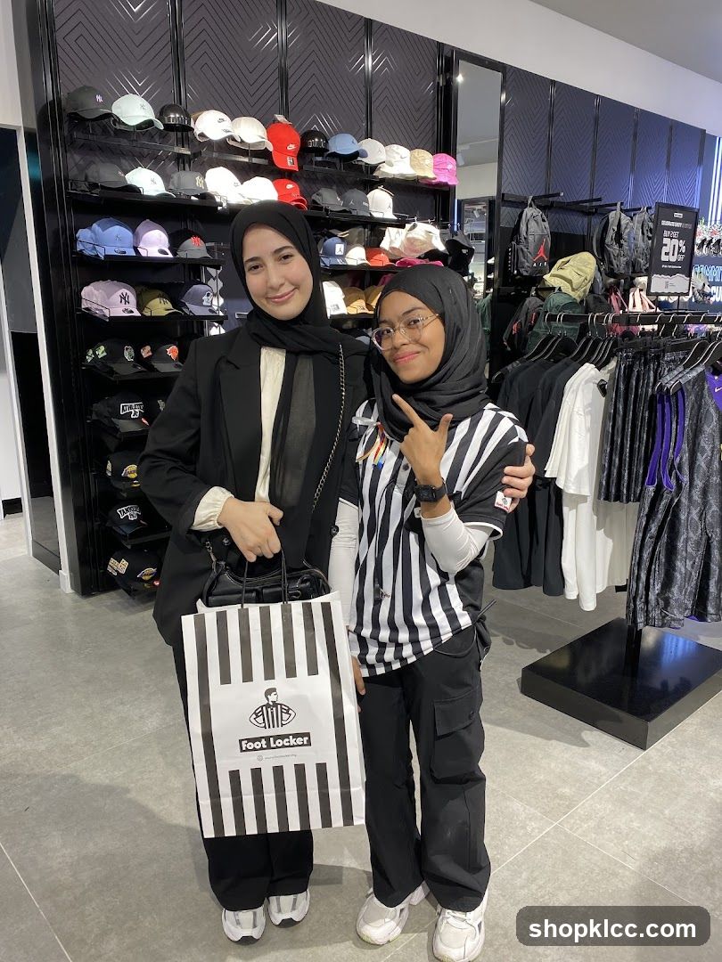 Two people posing in a Foot Locker store