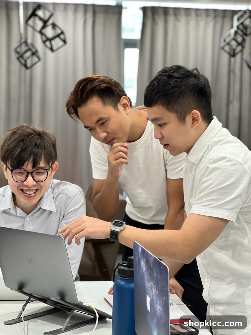 Three men looking at a laptop