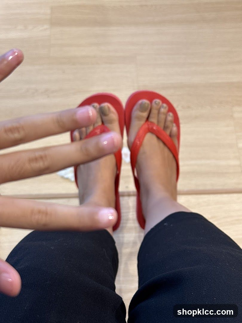 Feet with red flip-flops and painted toenails