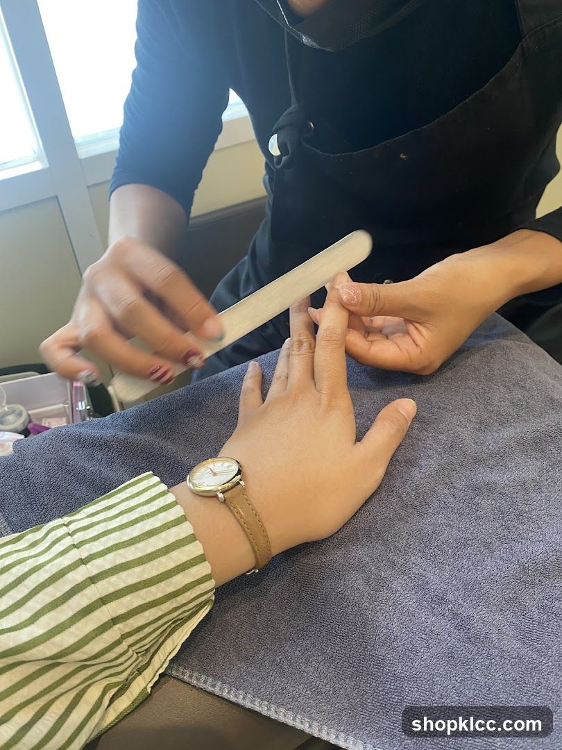 Manicurist Filing Client's Fingernail