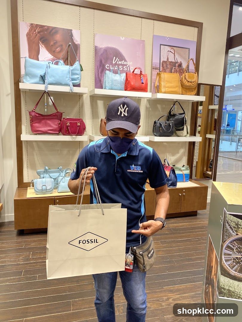 Man holding a Fossil shopping bag