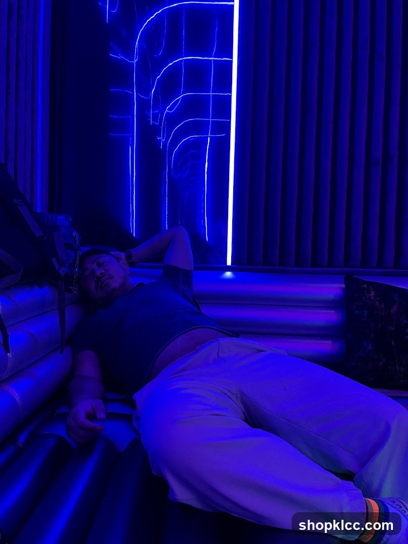 Man resting in a neon-lit room