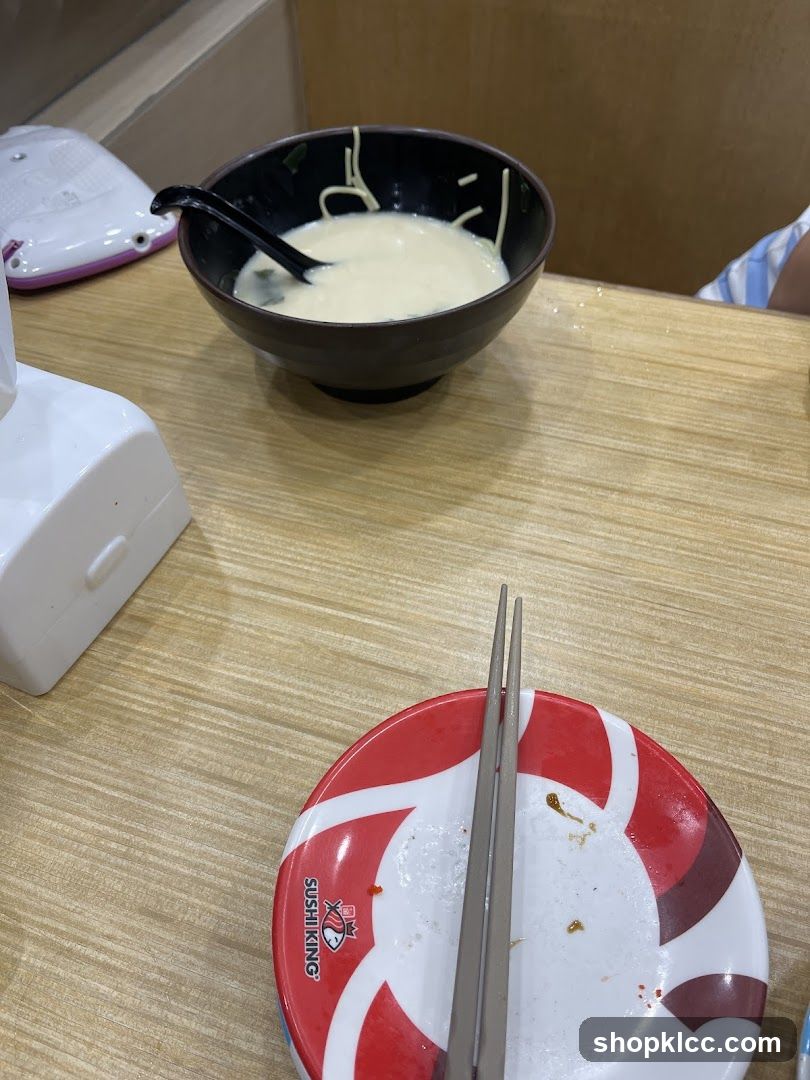 Bowl of noodles with soup and chopsticks on a plate