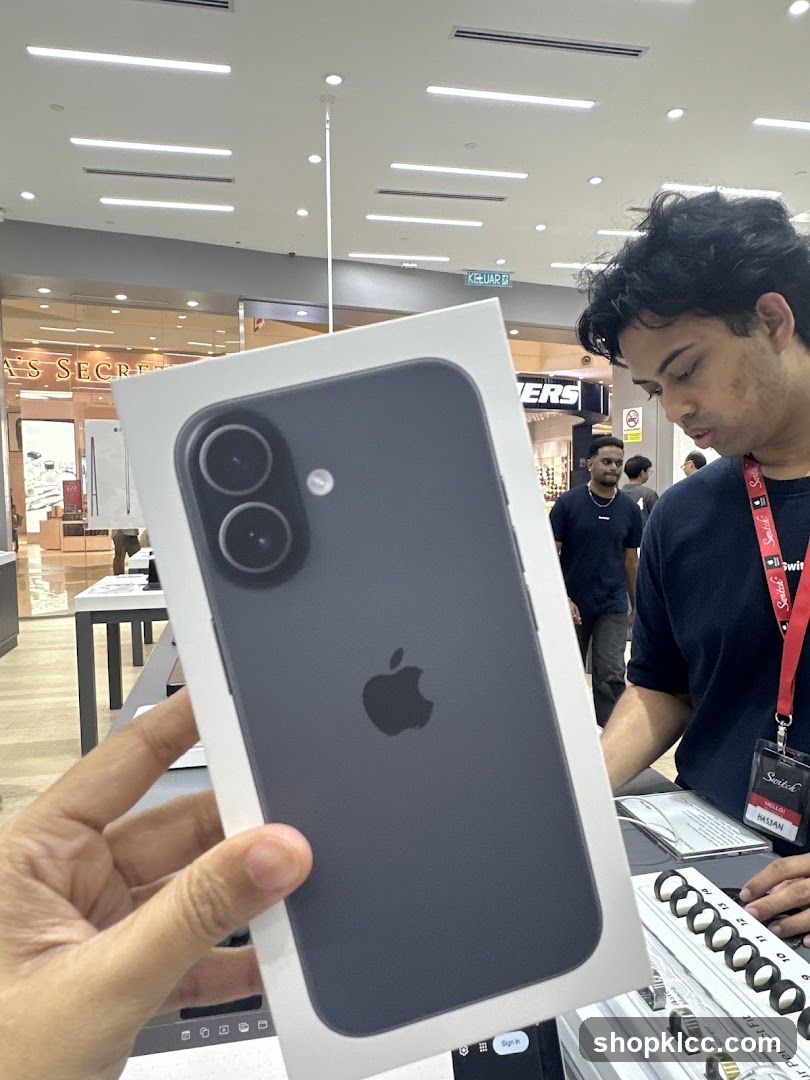 Person holding an iPhone box in a store