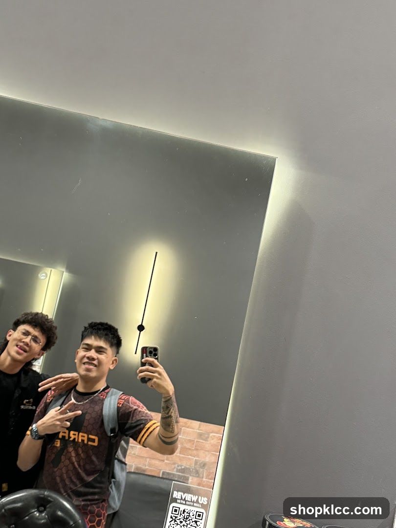 Two men taking a selfie in a mirror