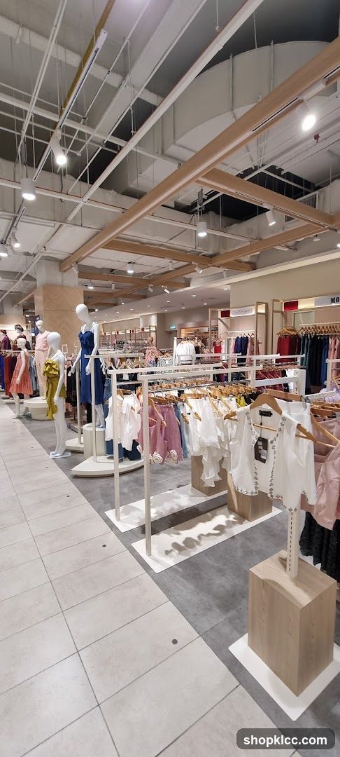 Clothing store interior with mannequins and racks of apparel.