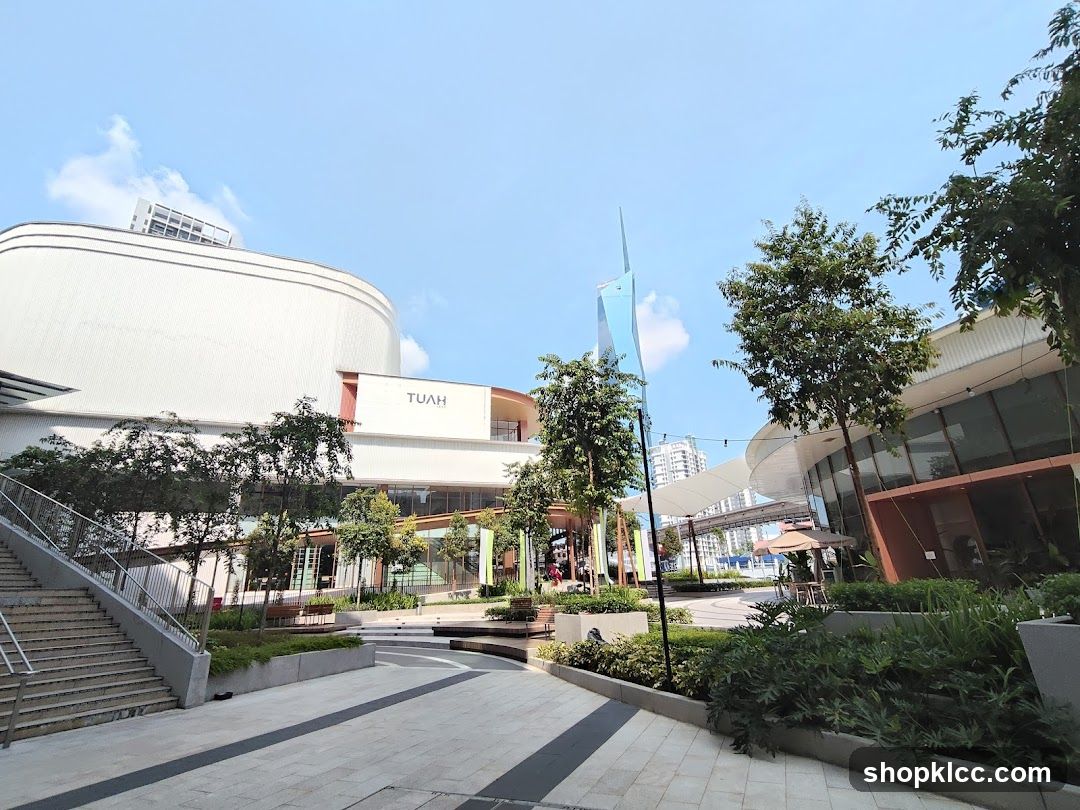 Modern outdoor plaza with shops and greenery