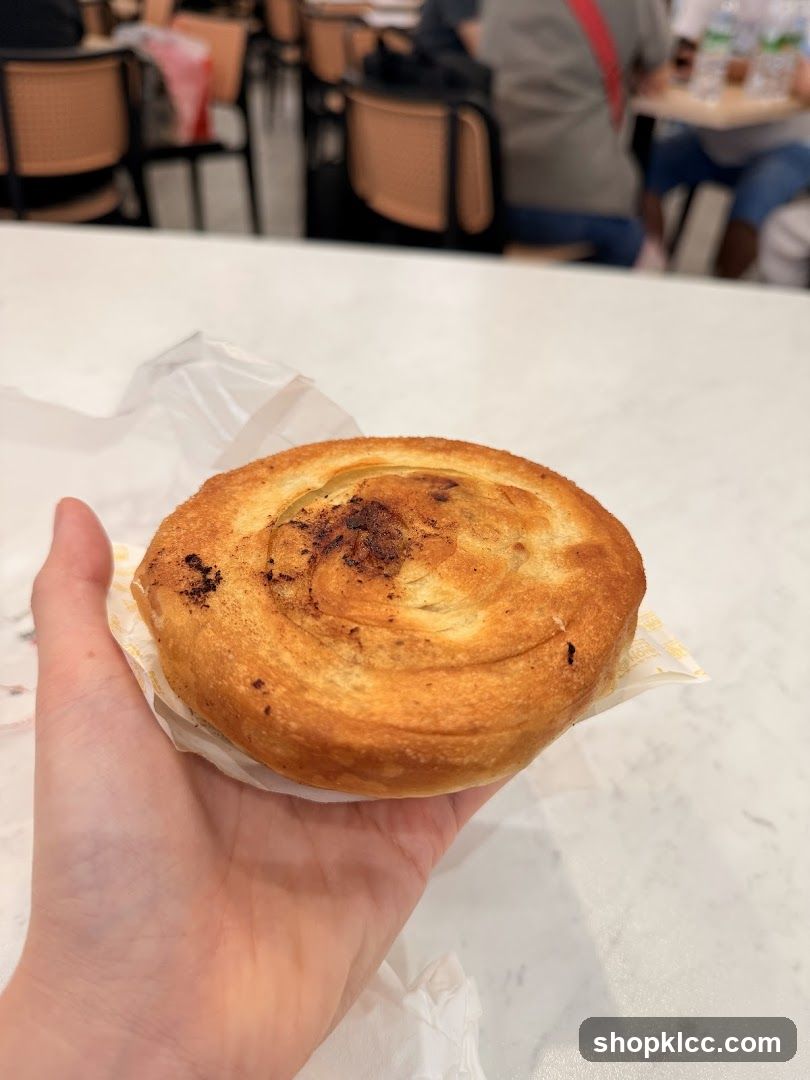 Hand holding a pastry in a cafe