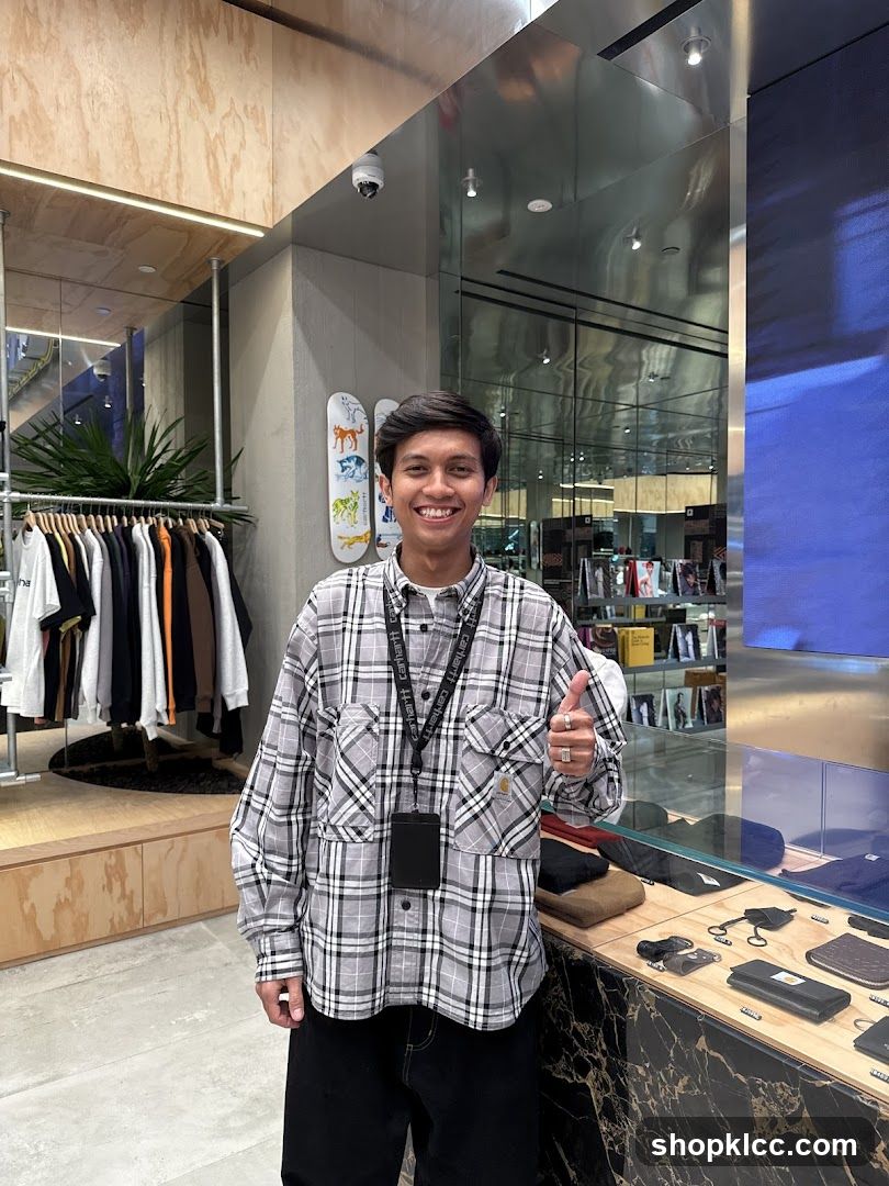 Man in Plaid Shirt Giving Thumbs Up in Store