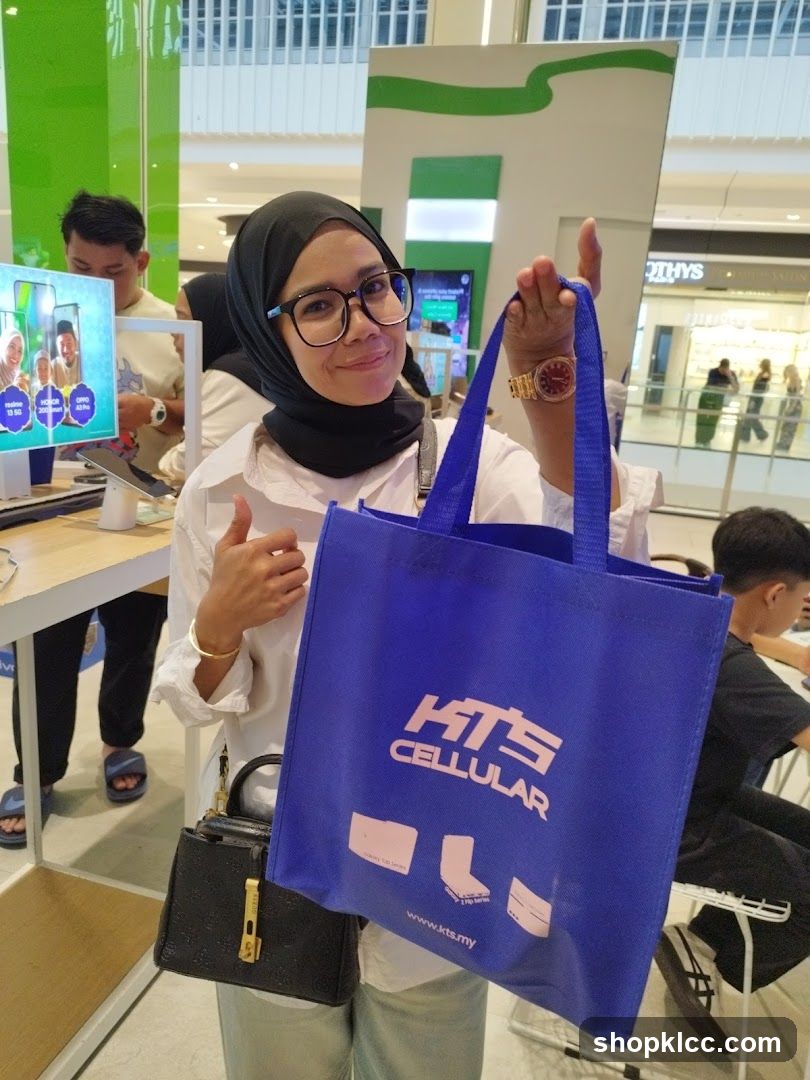 Woman holding a blue tote bag with KTS CELLULAR logo