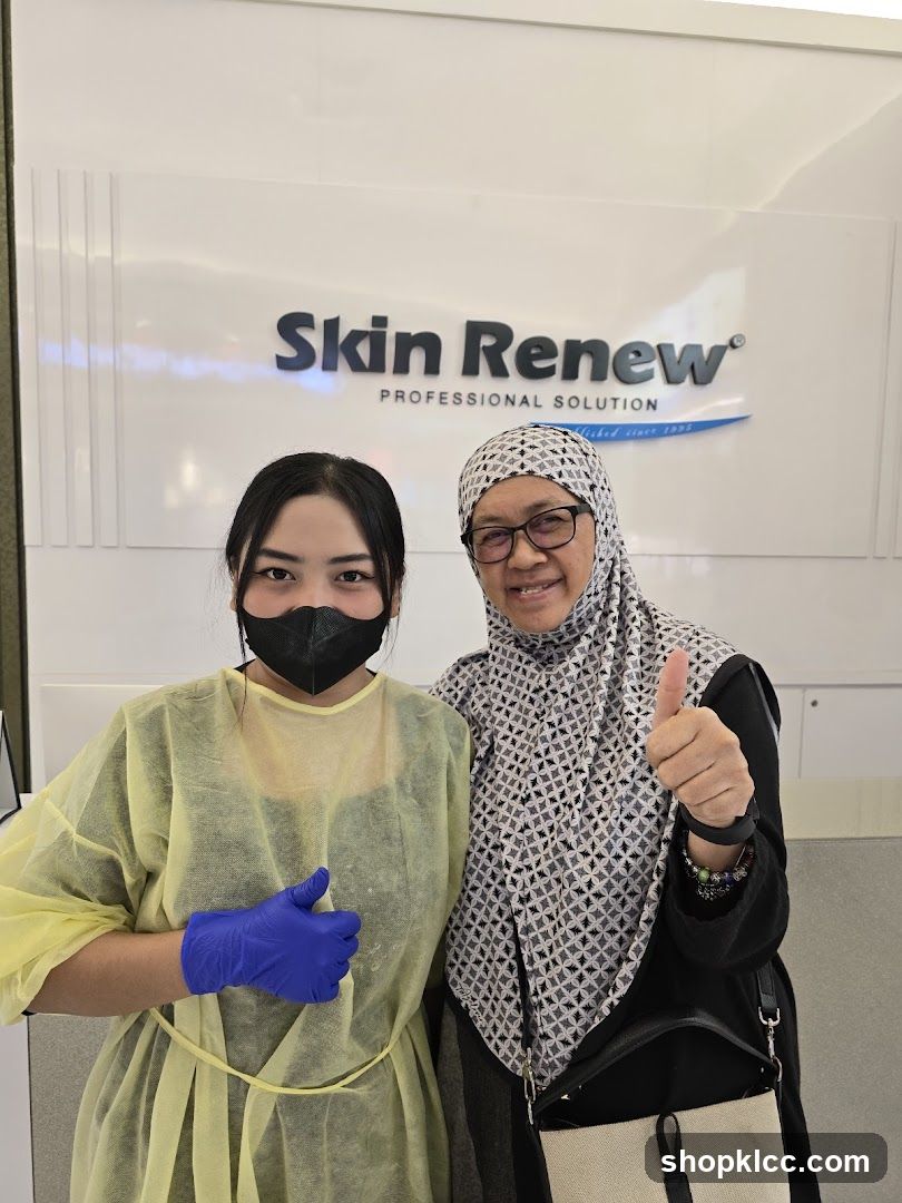 Two women posing in front of a Skin Renew sign