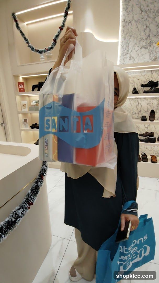 Woman holding shopping bag with "SANTA" logo