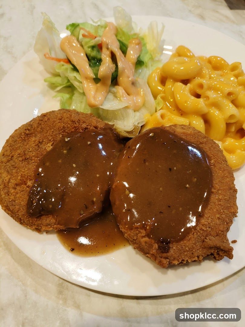 Breaded cutlets with gravy, macaroni and cheese, and salad