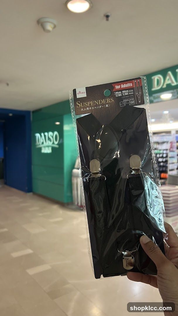 Hand holding packaged suspenders in mall corridor