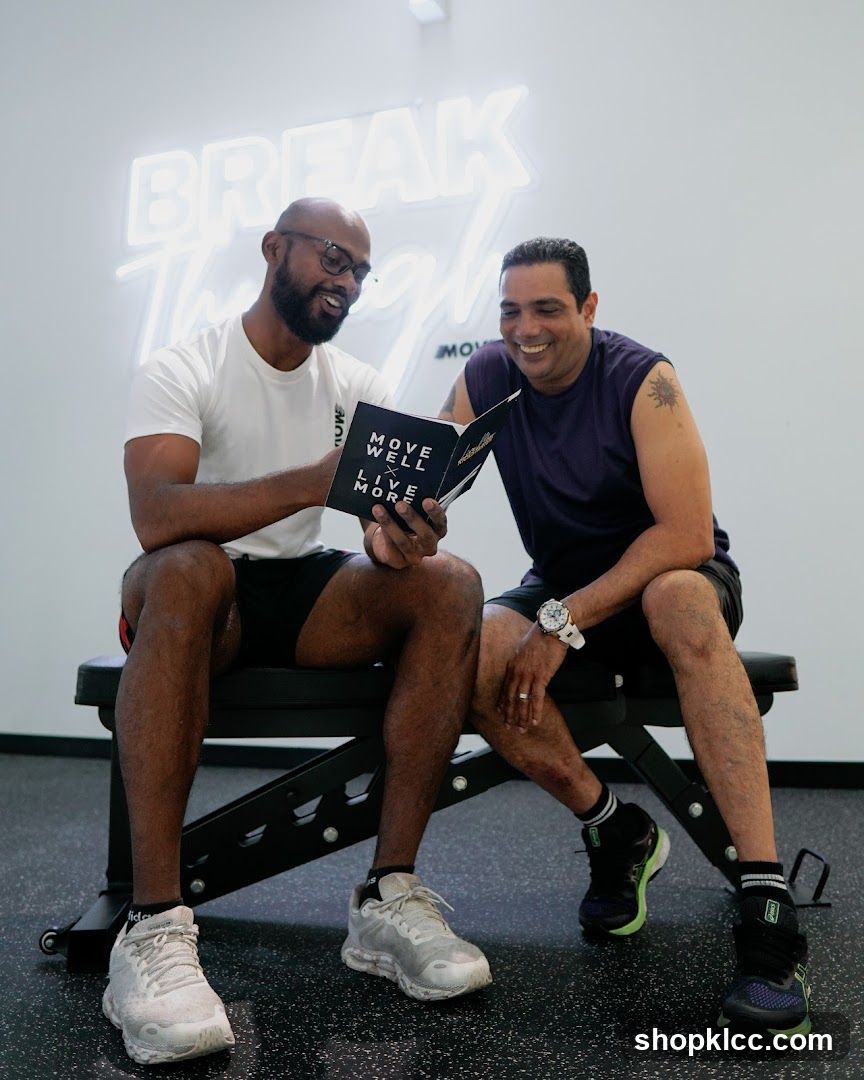 Two men looking at a book in a gym