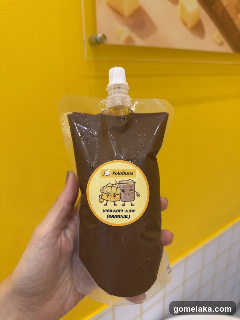 Hand holding iced kopi-kaw pouch