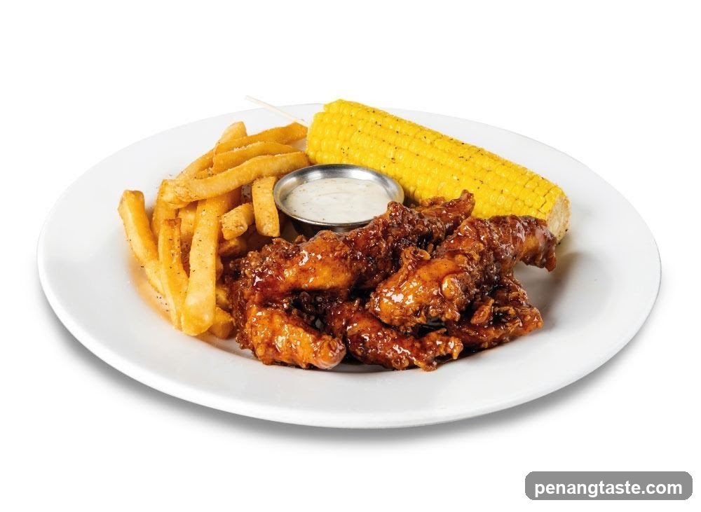Chicken tenders with fries and corn on the cob