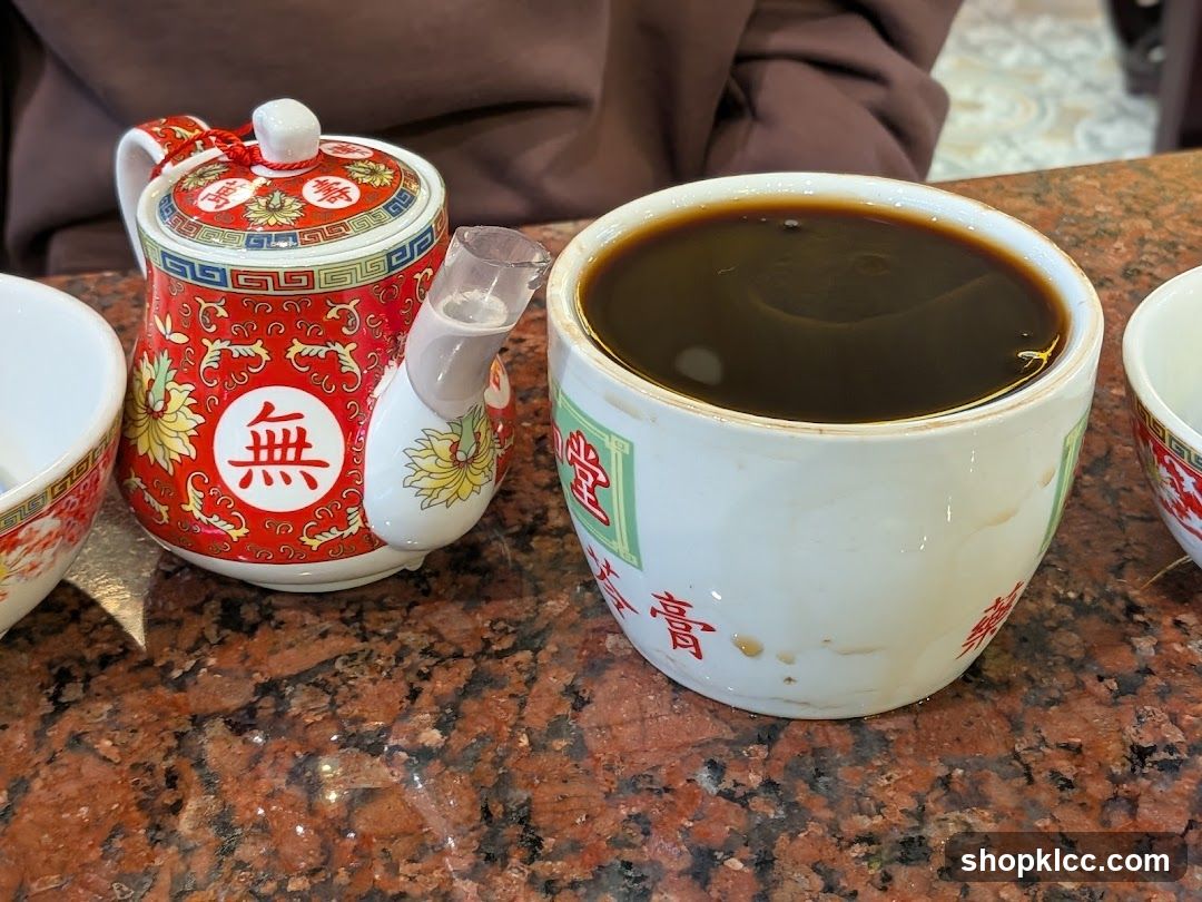 Teapot and Cup of Dark Liquid