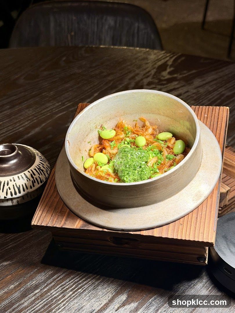 Bowl of food with green garnish and edamame beans