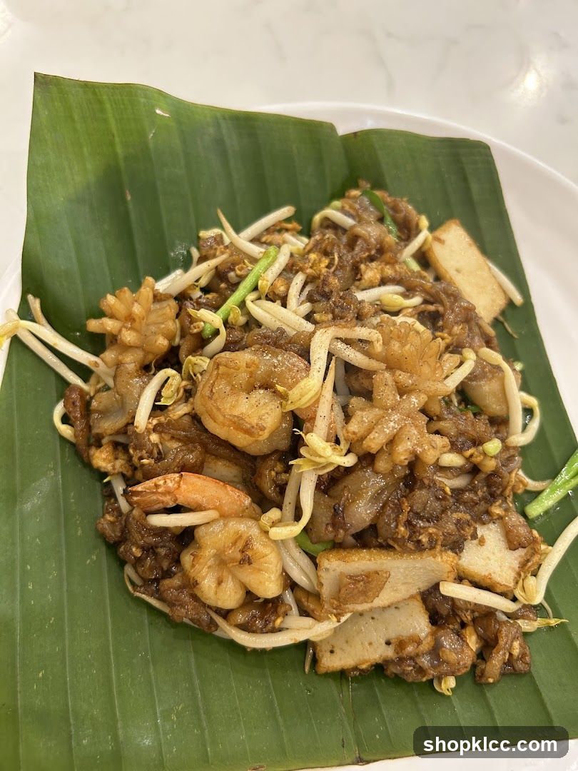 Stir-fried noodles with shrimp and tofu on banana leaf