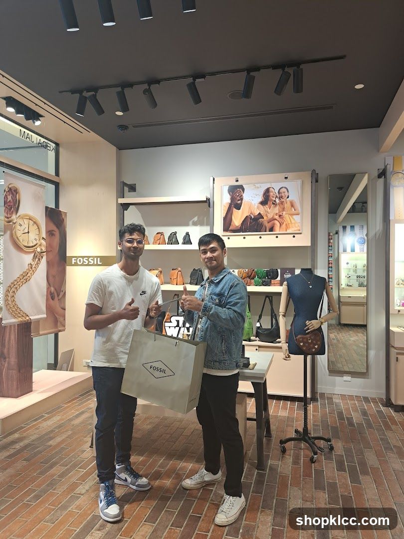 Two men posing with a Fossil shopping bag