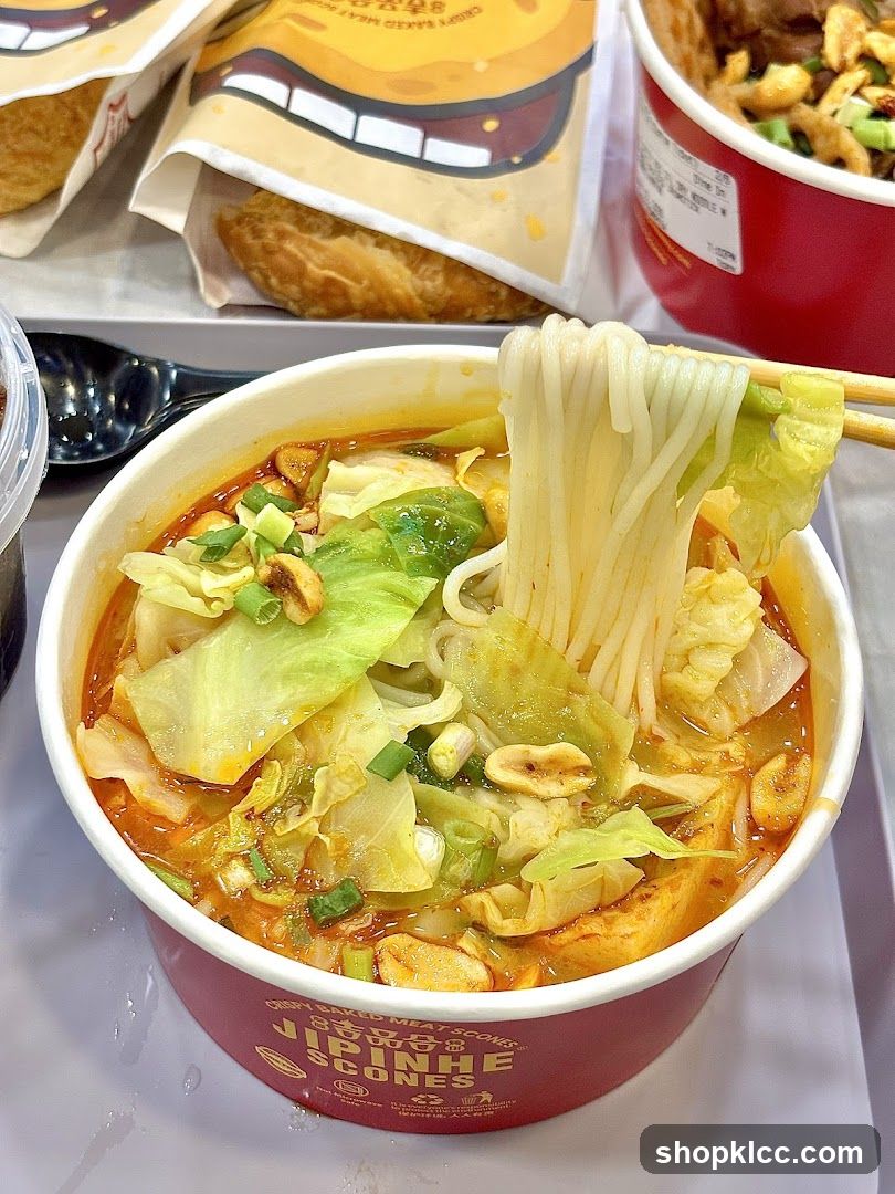 Bowl of Spicy Noodle Soup with Vegetables and Peanuts