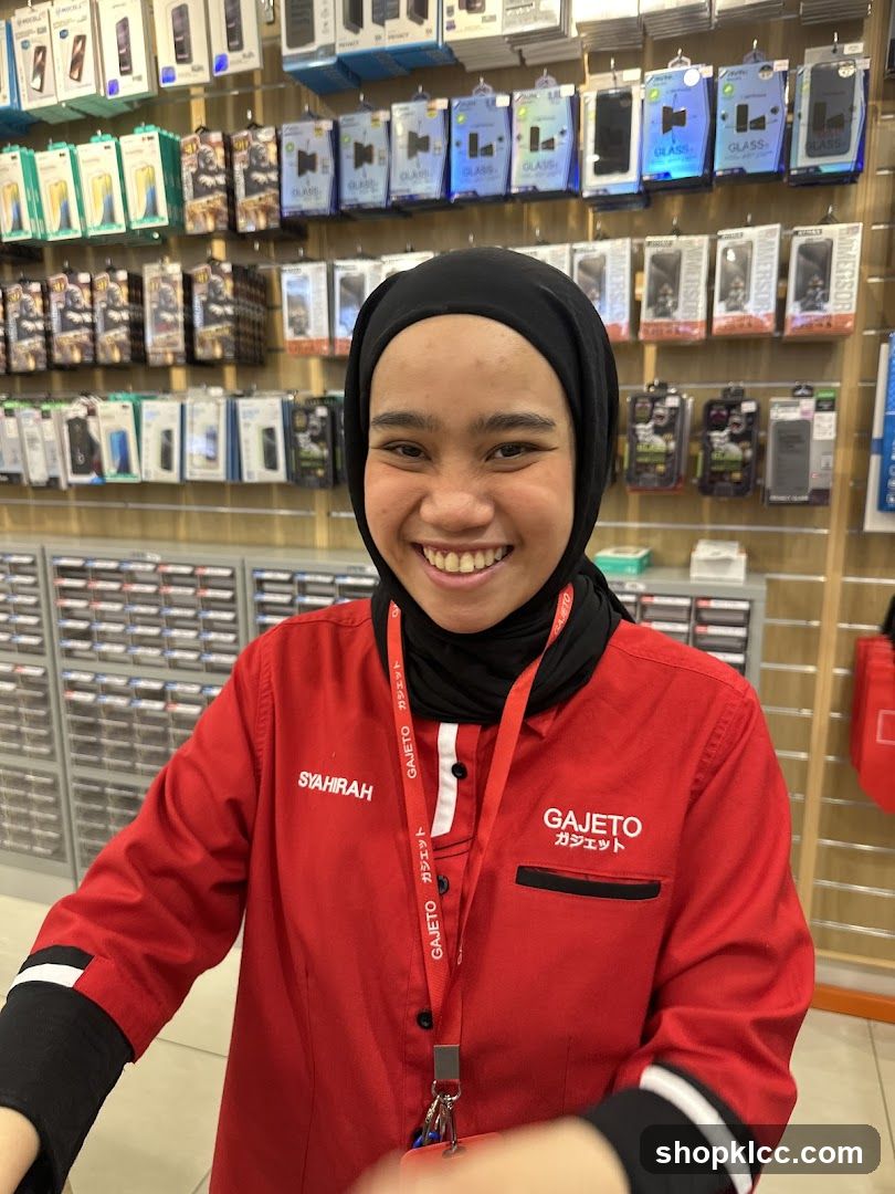 Staff in red uniform smiling at camera