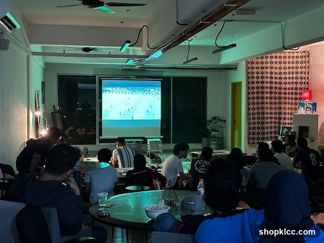 People watching a soccer match on a projector screen