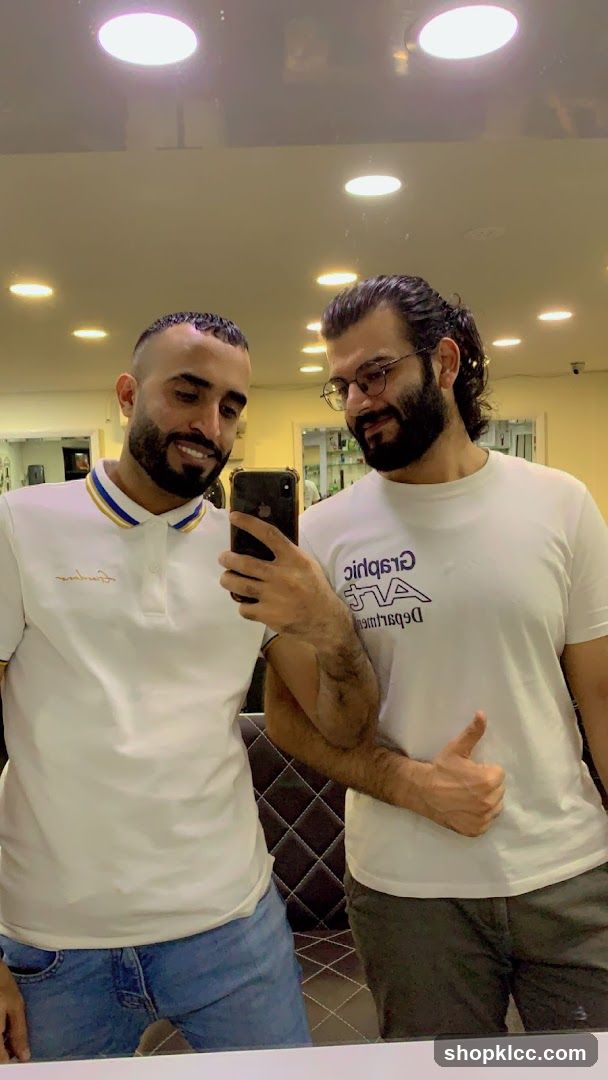 Two men in a salon or barbershop mirror selfie