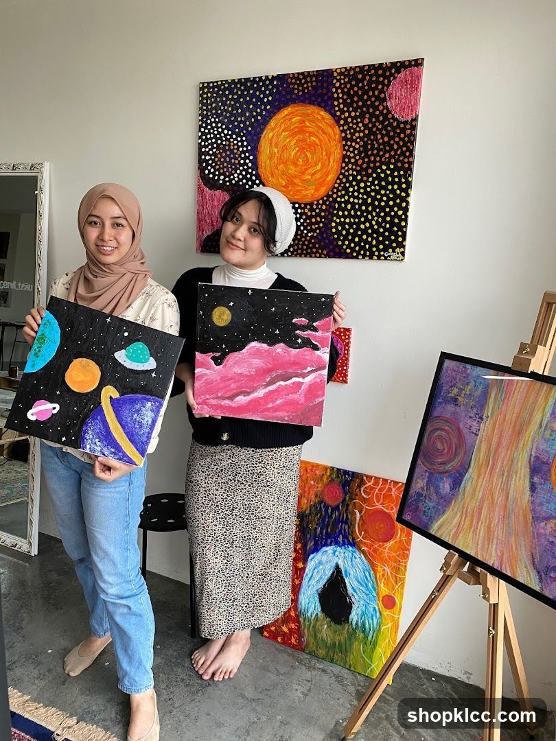 Two women holding paintings