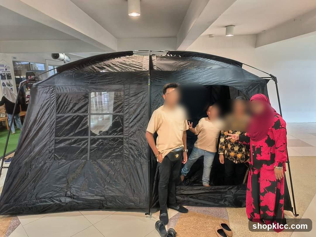 People posing in front of a large black tent