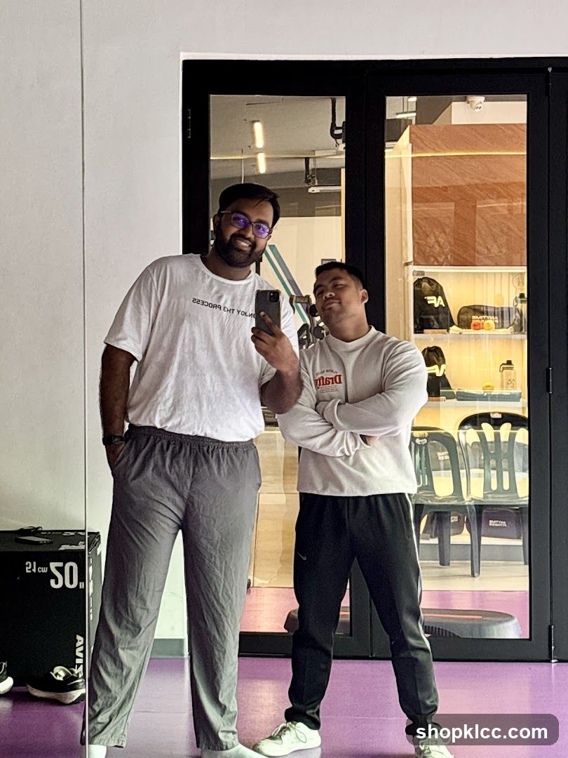 Two men taking a mirror selfie in a gym