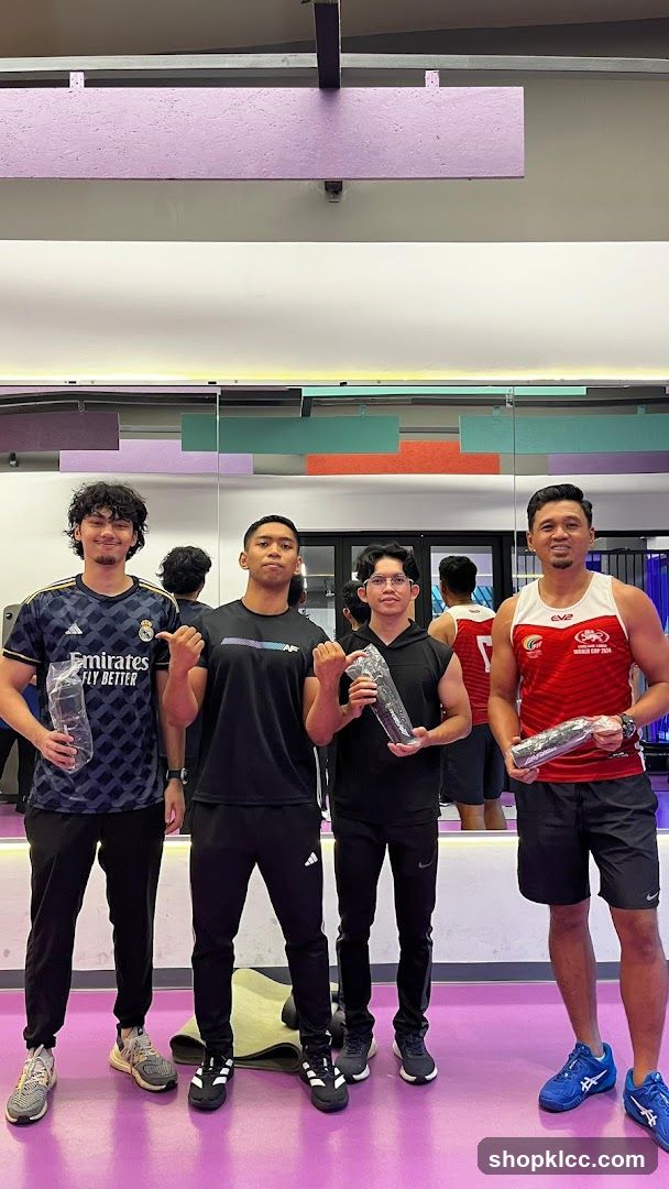 Four men posing in a gym