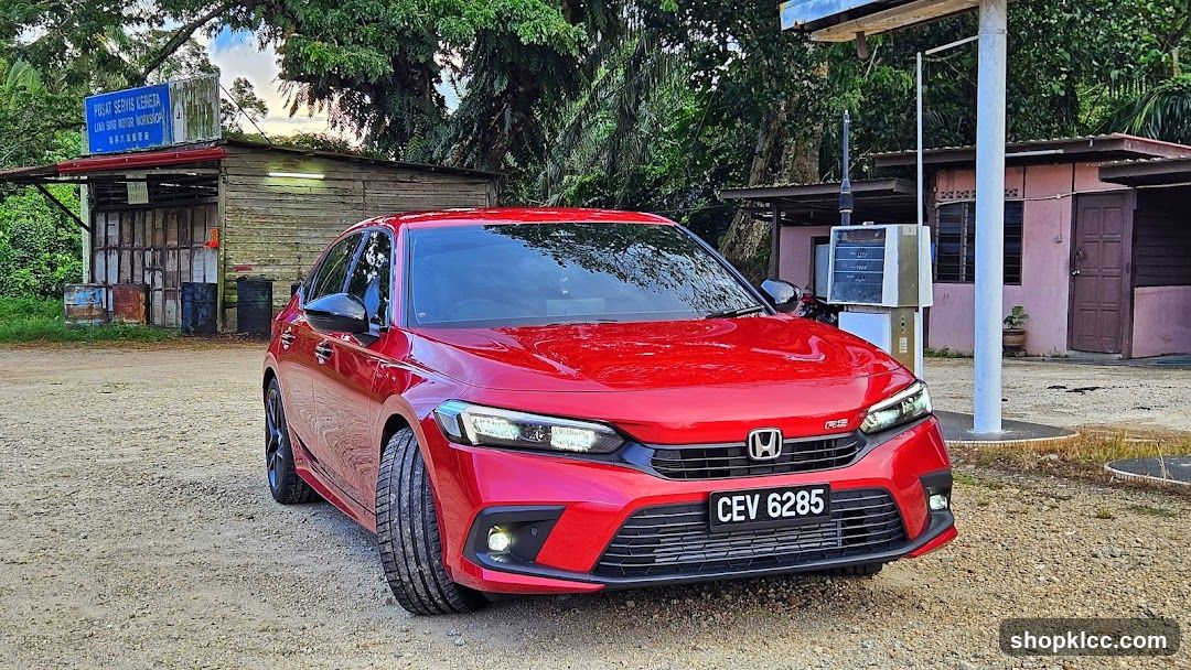 Red Honda Civic parked near a shop