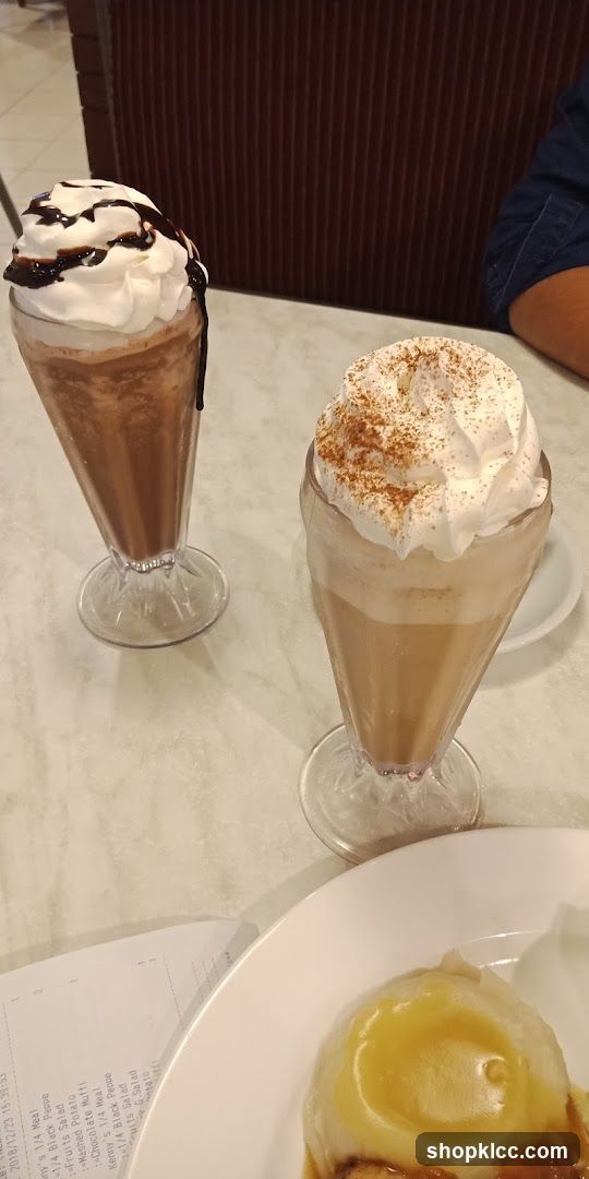 Two milkshakes and dessert on a table