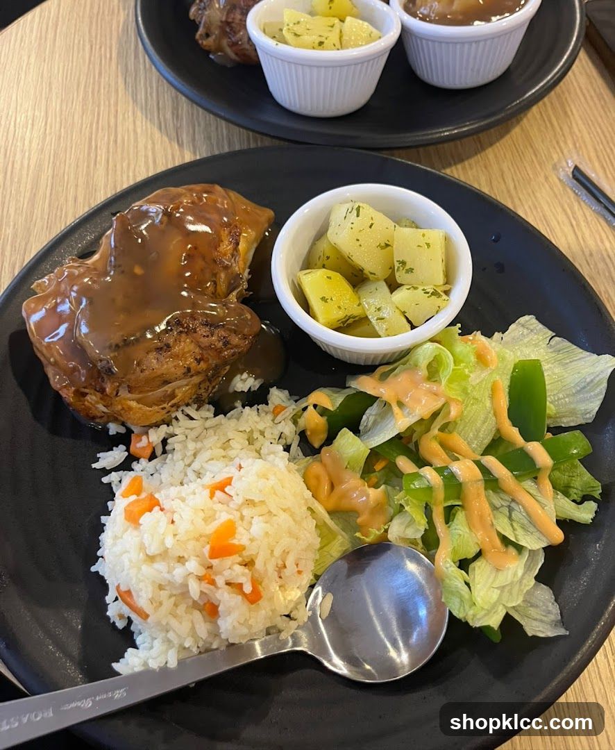 Plate of food with rice, meat, salad and side dishes