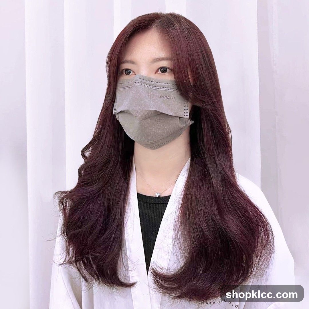 Woman with long, wavy, dark red hair wearing a mask