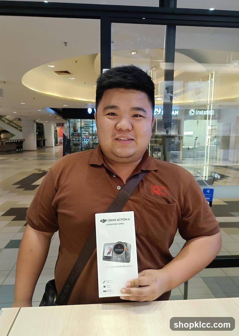 Man holding DJI Osmo Action 4 box in mall