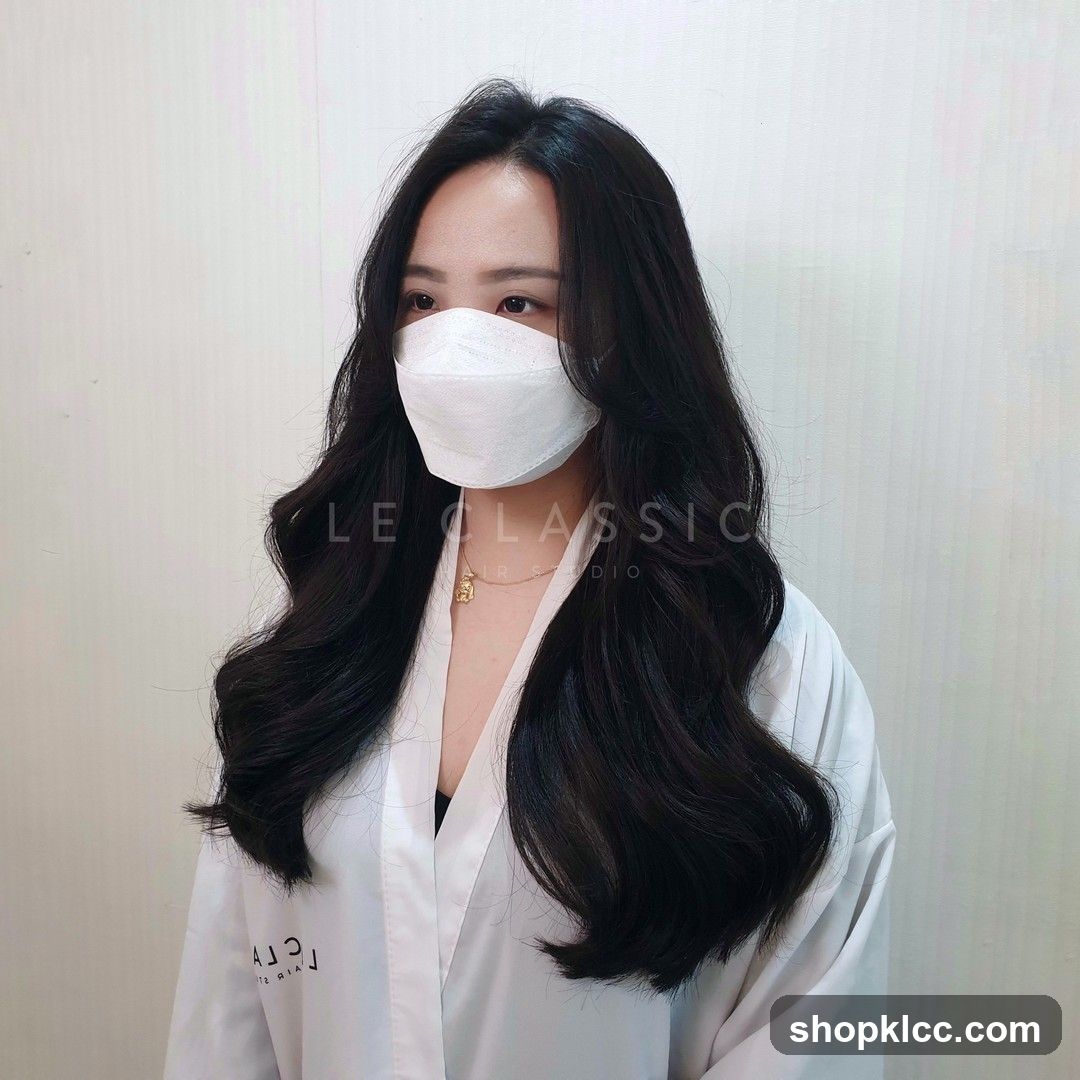 Woman with long, wavy black hair and a white mask