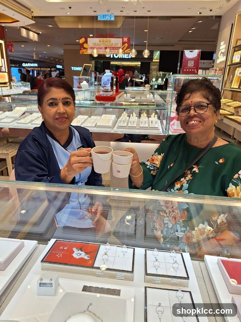 Two women enjoying drinks in a jewelry store