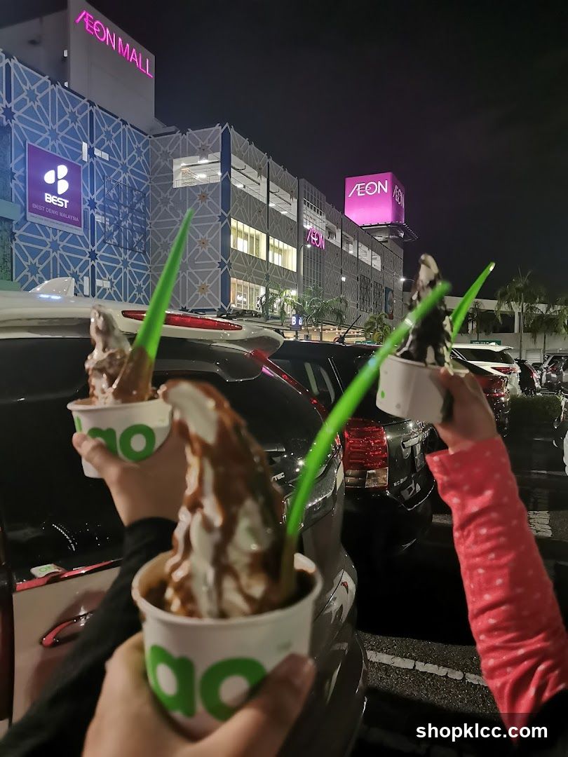 People holding ice cream cups outside a mall
