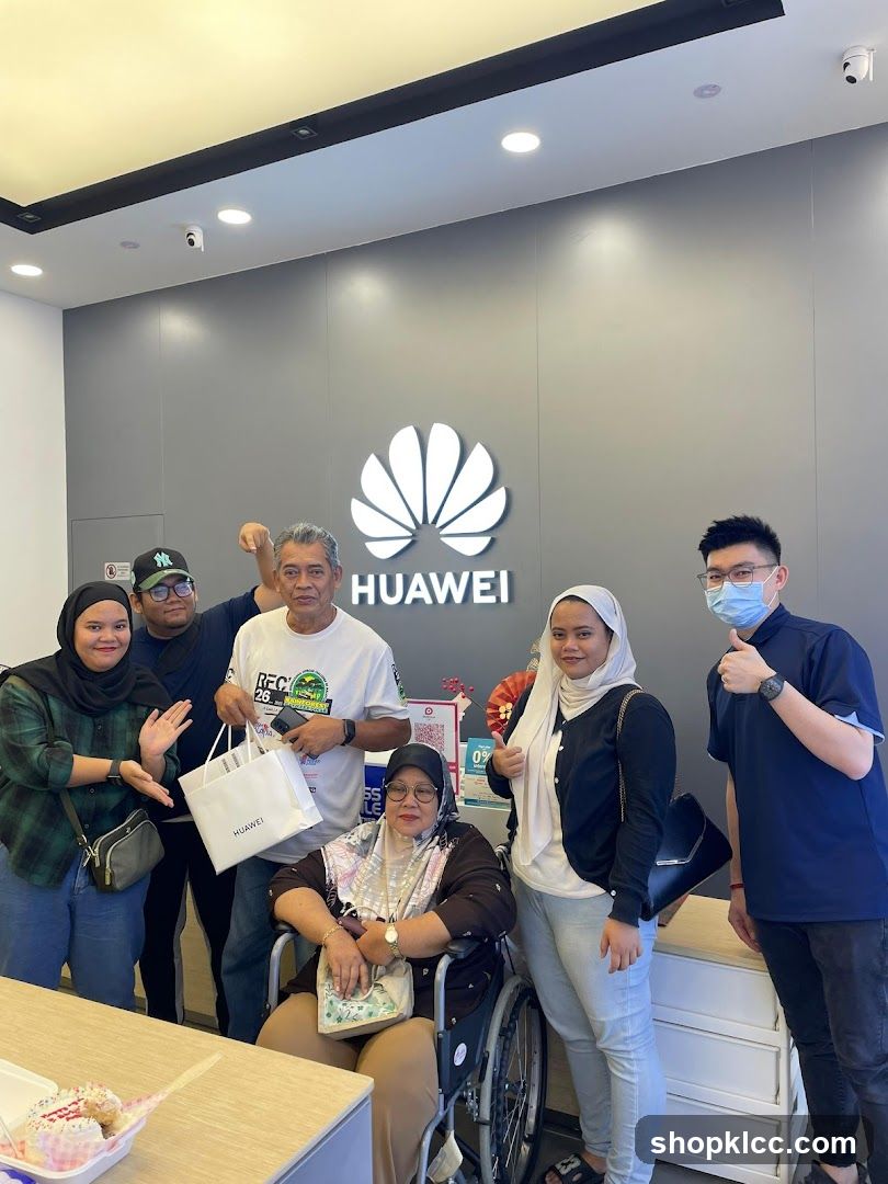 Group Poses in Front of Huawei Logo