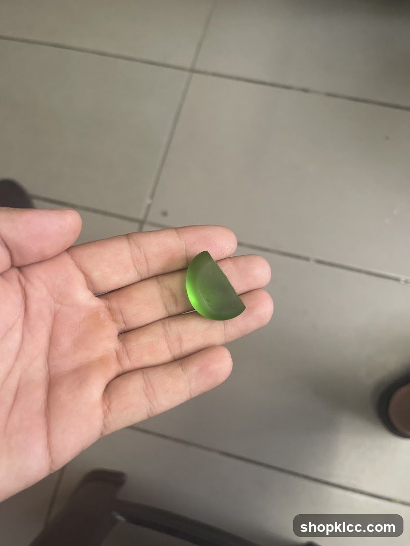 Hand holding green gemstone