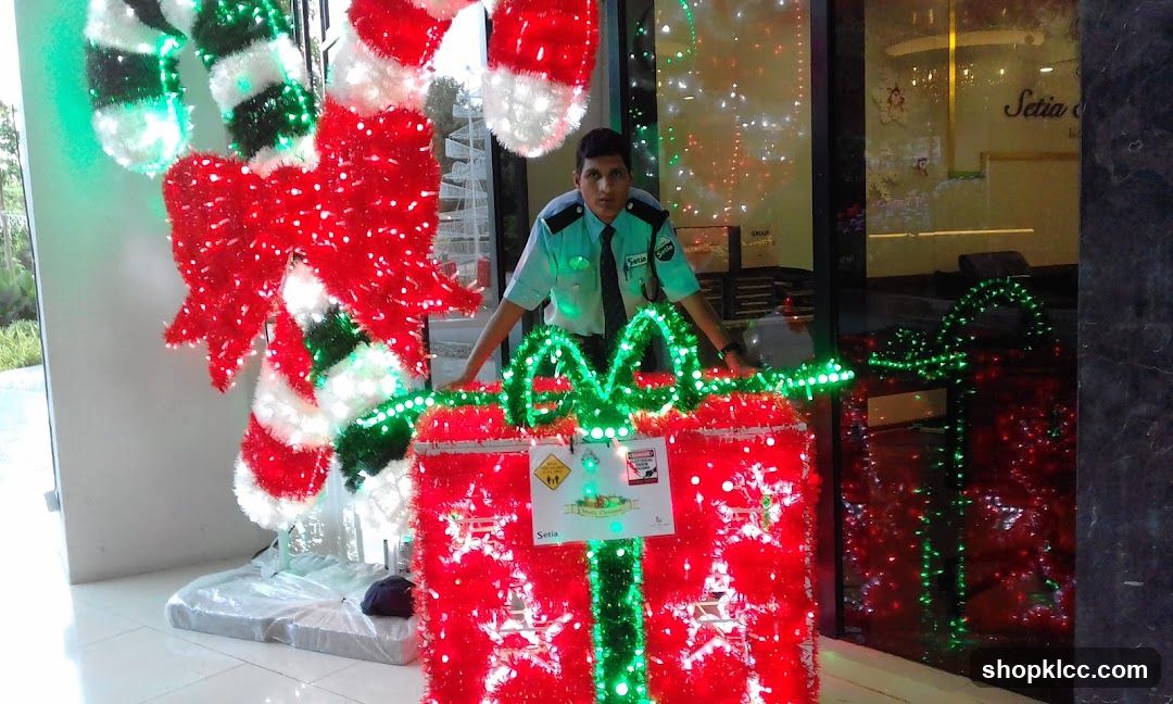 Security Guard Poses with Christmas Decorations