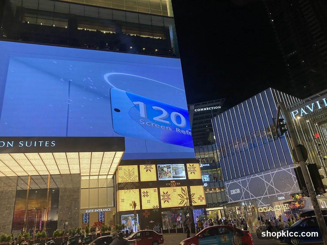Nighttime Cityscape with Large Digital Billboard and Storefronts